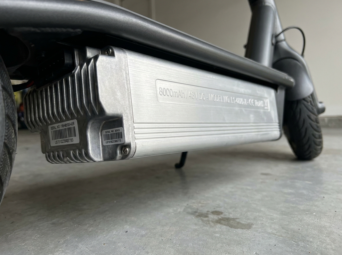 Gros plan sur la batterie lithium-ion d'une trottinette électrique haute capacité garée dans un parking urbain