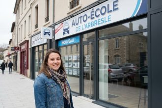 Jeune femme souriante devant une école de conduite à L'Arbresle