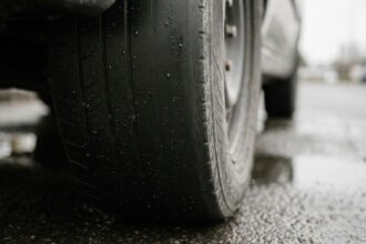 Gros plan sur un pneu lisse et usé sur route mouillée, risque d'accident automobile