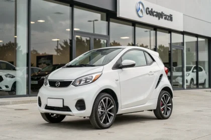 Voiture sans permis 4 places neuve blanche garée devant un concessionnaire automobile